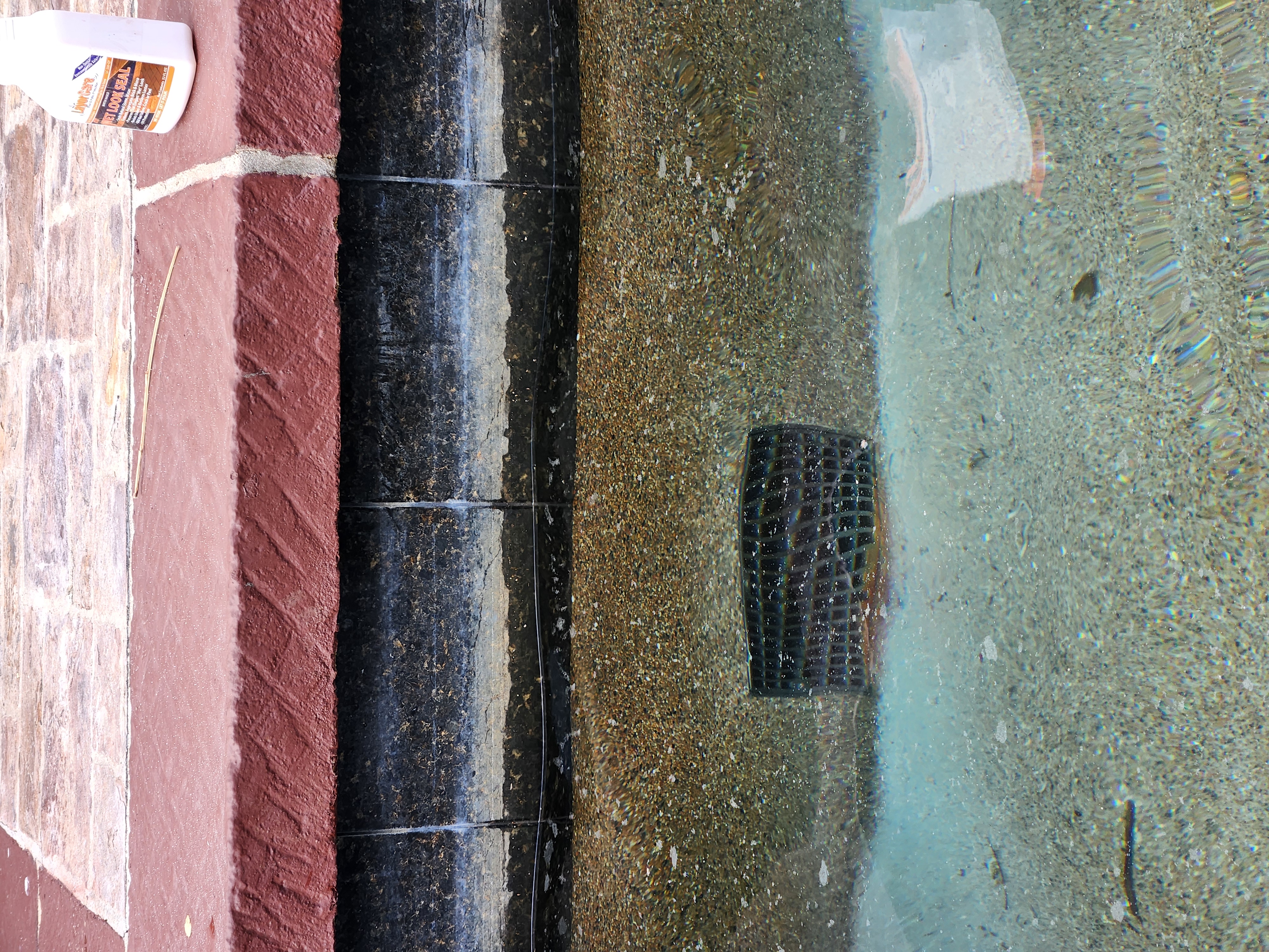 Pool waterline tile with heavy calcium buildup before restoration